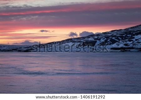 Frozen lake Ljosavatn, known as mirror lake during winter sunrise, Iceland
