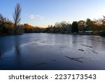 A frozen lake at sunset. There is ice on the surface of the lake in this winter scene. A cold winter