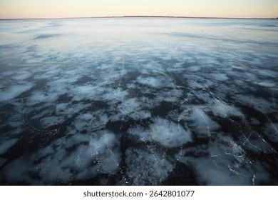 Frozen Lake Surface with Snow Patterns at Sunset - Winter Landscape and Nature Scene