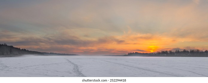 The frozen lake in the winter at sunset. Panorama