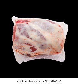Frozen Lamb leg in package isolated on black, top view