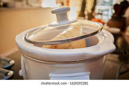 Frozen Lump Of Yellow Pea Soup With Ham Bits In A Crockpock (slow Cooker) With The Glass Lid On.