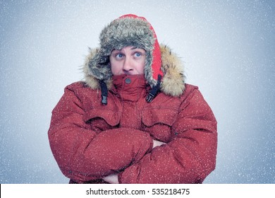 Frozen man in winter clothes warming hands, cold, snow, blizzard