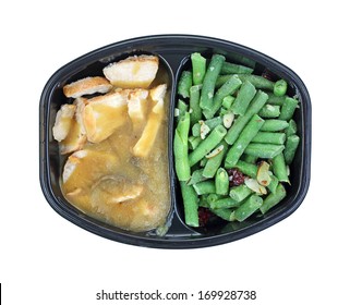 A Frozen Meal With Seasoned Turkey Tenderloin Slices In Gravy With Green Beans With Cranberries And Slivered Almonds.