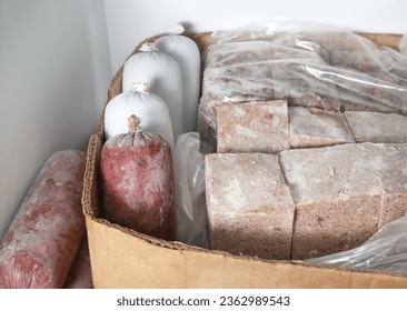 Frozen meat packages in freezer for raw food diet or barf for dogs, cats and pets. Many sausages and blocks. Organic human grade ground chicken and beef with muscle, bone and organs. Selective focus. - Shutterstock ID 2362989543