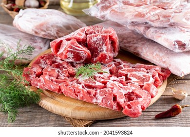 Frozen meat in a plastic bag on a wooden table. Frozen food. - Shutterstock ID 2041593824