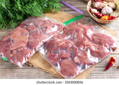 Frozen Offal, Liver, Heart, Stomachs In A Plastic Bag On A Wooden Table. Frozen Products. Frozen Food