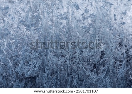 Frozen pattern of hoarfrost and frostwork structure on the glass. Color texture photo for background.