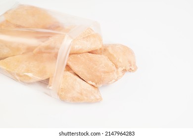 Frozen Pieces Of Chicken Fillet On An Isolated White Background.Chicken Fresh Meat In A Transparent Bag.