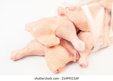 Frozen Pieces Of Chicken Leg On An Isolated White Background.Chicken Fresh Meat In A Transparent Bag.