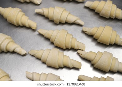 Frozen pieces for croissants on a baking sheet in a bakery