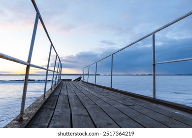 Frozen pier is under sunset sky in the evening, perspective view. Winter landscape - Powered by Shutterstock