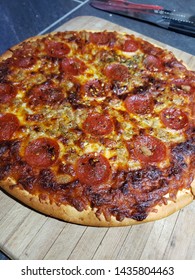 Frozen Pizza Cooked To Perfection On A Cutting Board