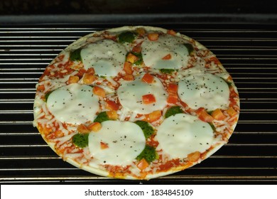 Frozen Pizza Heating In Oven. High Angle. Convenience Food