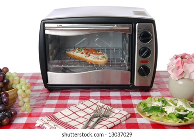 A Frozen Pizza Heats Up In A Toaster Oven