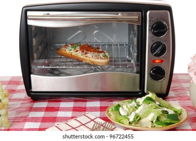 A Frozen Pizza Heats In A Toaster Oven