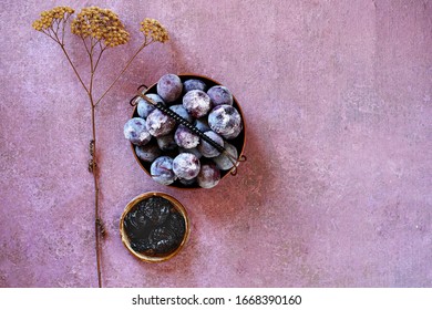 Frozen Plum With Ice Cubes In A Basket And A Gravy Boat With Prunes, Next To A Field Dried Flower . Top View, Copy Space..