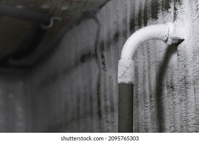 Frozen plumbing with a thick layer of white frost in the chilly cold winter. The frozen water pipe froze in the harsh winter at low temperatures.