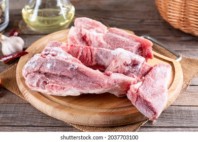 Frozen pork meat on a cutting board. Frozen pork bones. Frozen food