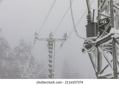 Frozen Power Line Pylons. Hoarfrost On High Voltage Cables And Pylons. Winter In The Mountains.