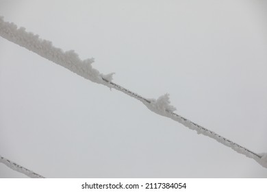 Frozen Power Line Pylons. Hoarfrost On High Voltage Cables And Pylons. Winter In The Mountains.