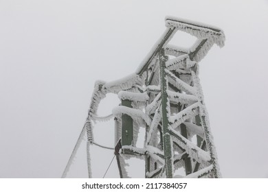 Frozen Power Line Pylons. Hoarfrost On High Voltage Cables And Pylons. Winter In The Mountains.