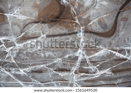 Frozen puddle with broken ice. Winter season.