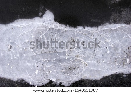 Frozen puddle with broken ice. Winter season.