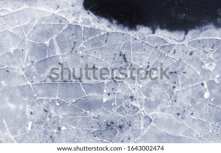 Frozen puddle with broken ice. Winter season.