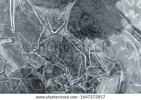 Frozen puddle with broken ice. Winter season.