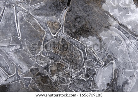 Frozen puddle with broken ice. Winter season.