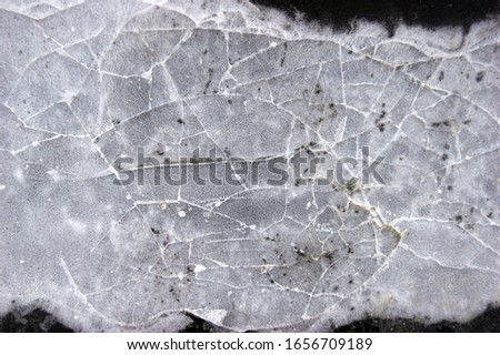 Frozen puddle with broken ice. Winter season.