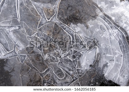 Frozen puddle with broken ice. Winter season.