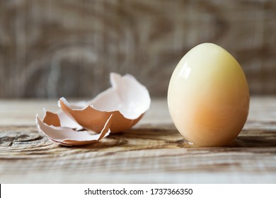 Frozen Raw Egg And Shell On A Wooden Board