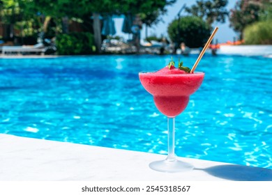 Frozen red drink by the pool on sunny day. Concept of refreshing summer poolside relaxation - Powered by Shutterstock