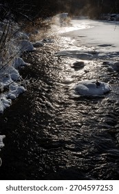 frozen river currents, snowcovered stream with icy patches and submerged stones creating turbulence, frozen waterway with scattered ice fragments and wet rocks generating gentle moving flows
