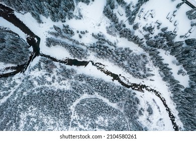 Frozen River In Snow Covered Forest. Top Down Drone View.