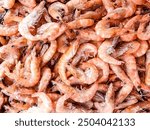 Frozen shrimps prawns. Raw shrimp background. Pile of frozen shrimps background. Close-up of frozen shrimps. Shrimp with ice, top view.