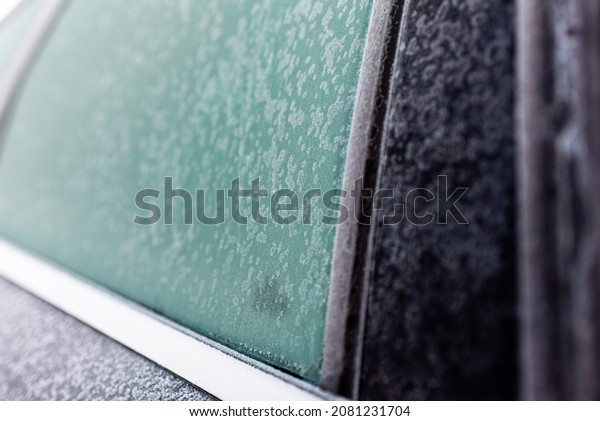 Frozen side window of the\
car.frozen car. the side of the car doors covered with frost.\
closeup.
