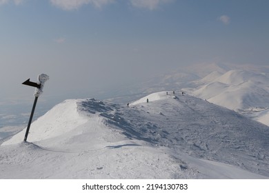 Frozen Sign Post And Skiers On Mountain Ridge, Niseko, Japan