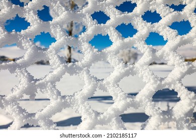 frozen snowflakes on a snow-covered wire fence
