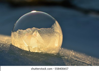 Frozen soap bubble. Cold winter liquid ball experiment. Freezing water with icy patter texture