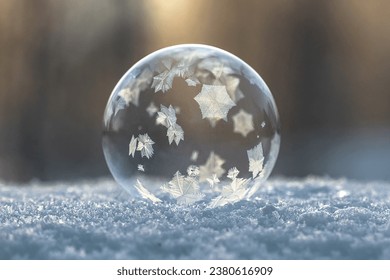 Frozen soap bubble with patterns on snow