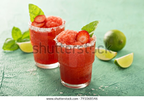 Frozen\
strawberry lime basil margarita in\
glasses