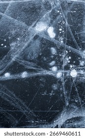 Frozen surface with intricate ice patterns showcasing bubbles and cracks in a cold environment. Background frozen ice from Lake Baikal top view