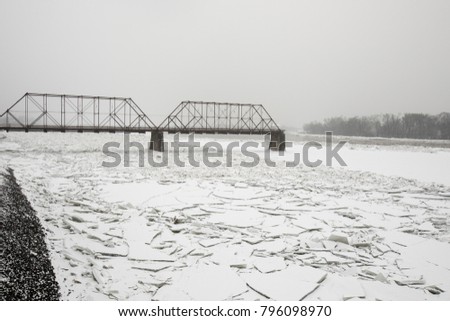 Frozen Susquehanna RIver banks in Harrisburg, PA on snowy winter day.