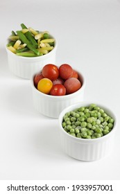 Frozen Vegetables Assorted In Bowls Isolated On White Background, Closeup, Saving Leftovers, Food Storage Concept And Eating Meals At Home Concept