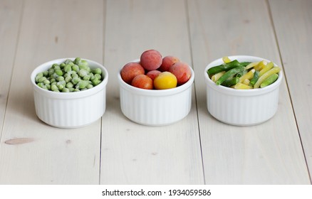 Frozen Vegetables Assorted In Bowls Isolated On White Background, Closeup, Saving Leftovers, Food Storage Concept And Eating Meals At Home Concept