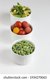 Frozen Vegetables Assorted In Bowls Isolated On White Background, Closeup, Saving Leftovers, Food Storage Concept And Eating Meals At Home Concept