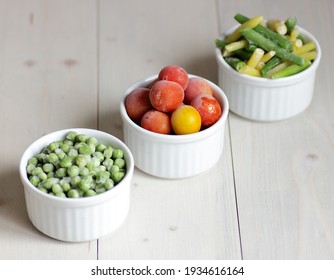 Frozen Vegetables Assorted In Bowls Isolated On White Background, Closeup, Saving Leftovers, Food Storage Concept And Eating Meals At Home Concept